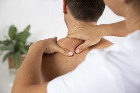 Physiotherapist performing therapeutic massage male client
